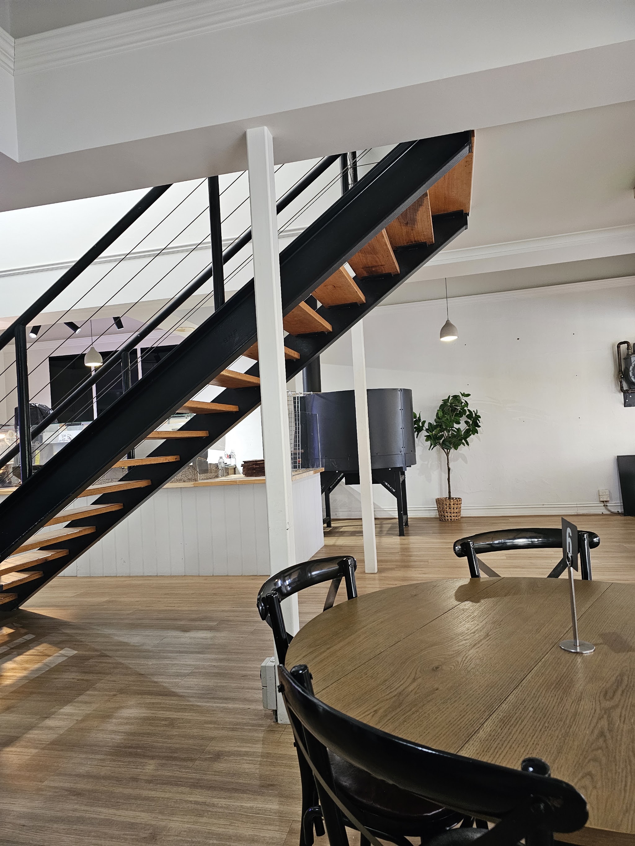 The staircase up to the balcony, with the pizza oven and servery behind